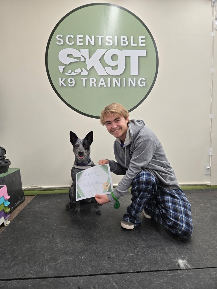 A dog and their owner celebrating finishing a group class